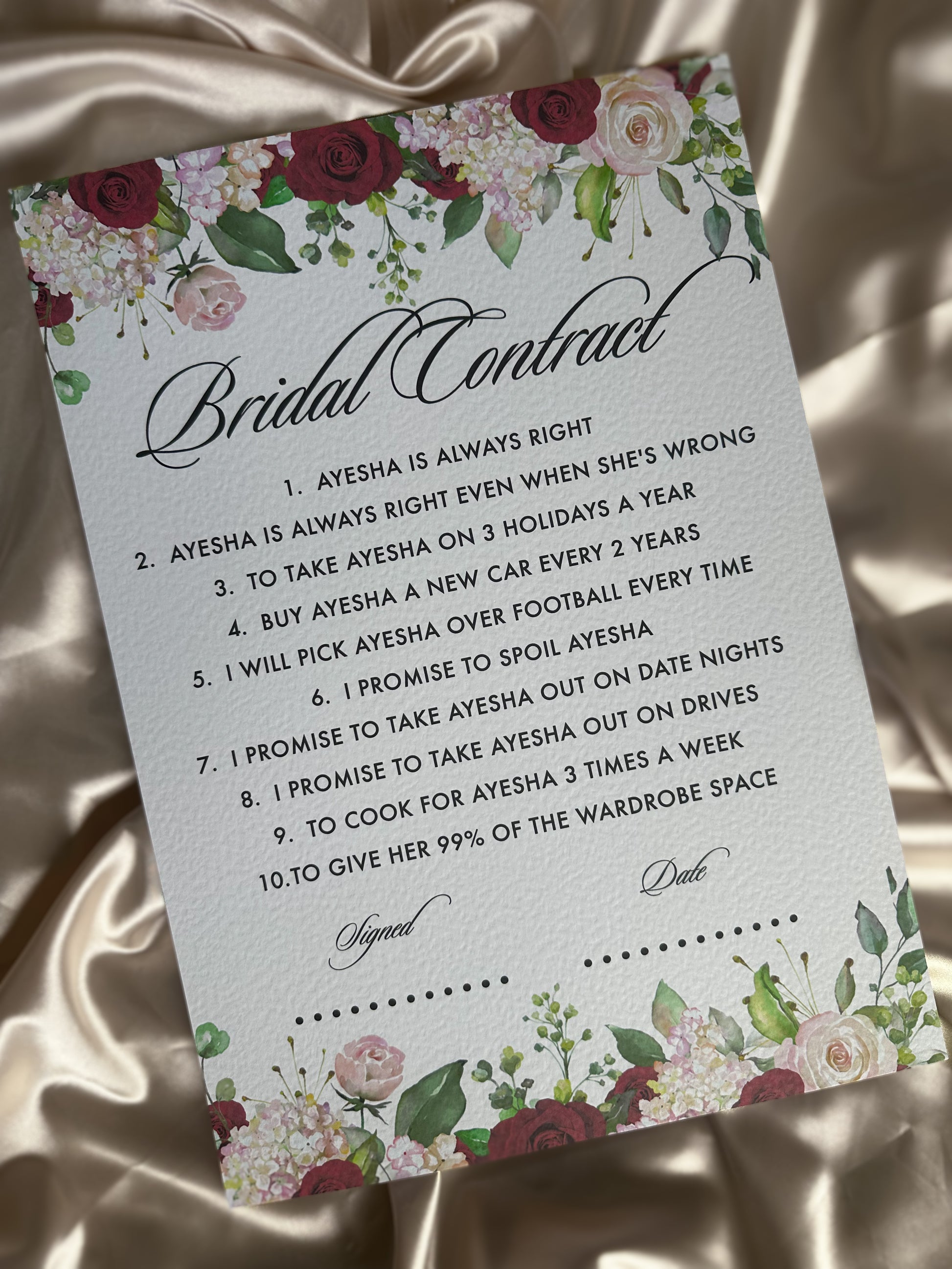 Bridal contract card with floral design on a satin background